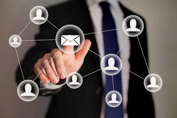 Businessman interacting with a digital network of people and email icons.